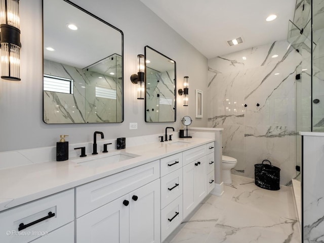 bathroom with vanity, tiled shower, and toilet