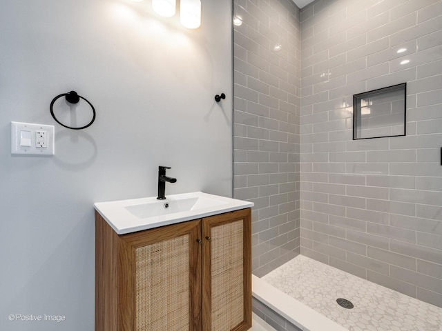 bathroom with vanity and tiled shower