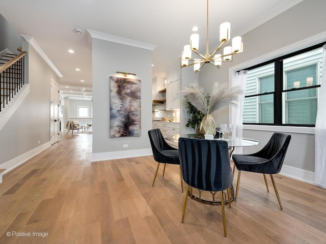 dining area with ornamental molding, a chandelier, and light hardwood / wood-style floors