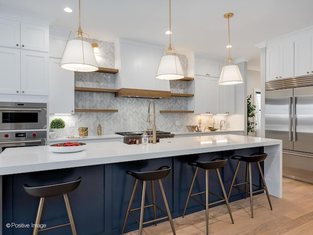 kitchen featuring stainless steel appliances, white cabinetry, and a breakfast bar