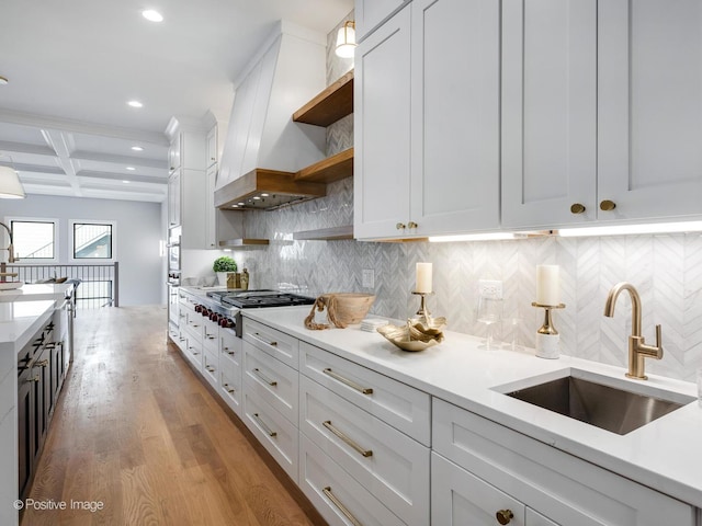 kitchen with beamed ceiling, white cabinetry, coffered ceiling, and custom range hood