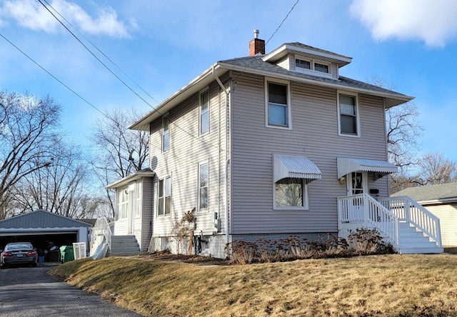 view of front of home featuring a garage, an outbuilding, and a front yard