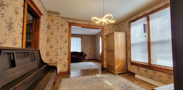 interior space with parquet flooring, a baseboard heating unit, and an inviting chandelier