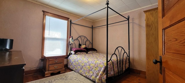 bedroom featuring crown molding and dark hardwood / wood-style flooring