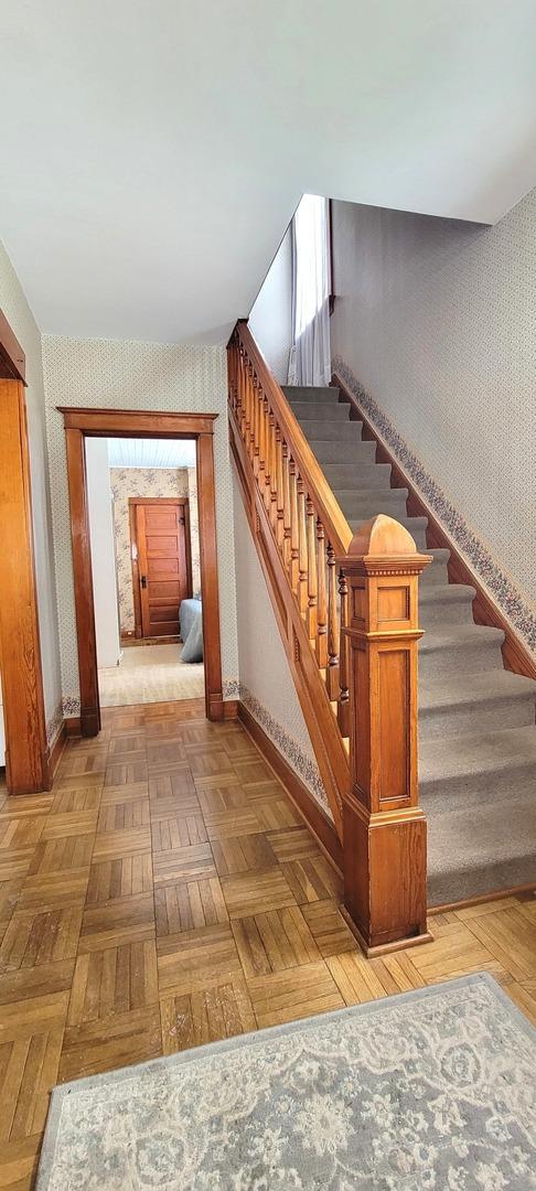 stairway featuring parquet floors