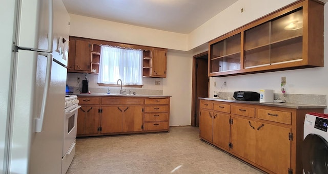 kitchen featuring sink, washer / dryer, and white appliances