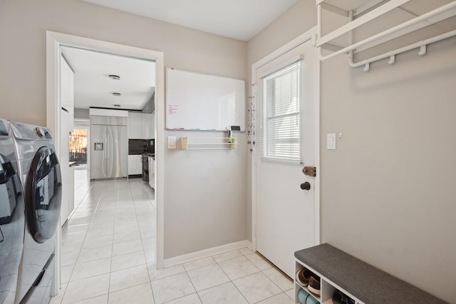 washroom with washing machine and clothes dryer and light tile patterned flooring