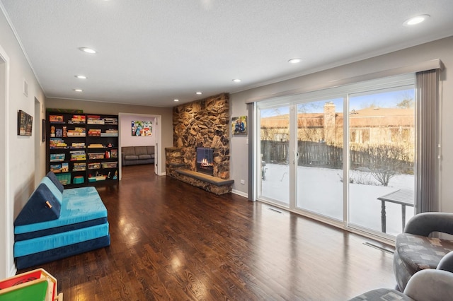 living area with plenty of natural light, dark hardwood / wood-style floors, and a textured ceiling