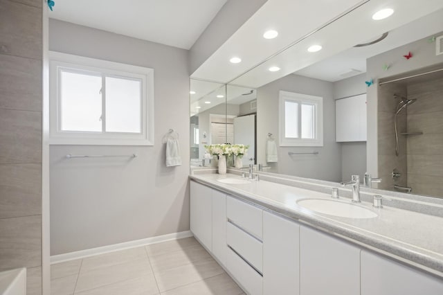 bathroom featuring vanity, tile patterned floors, a healthy amount of sunlight, and bathtub / shower combination