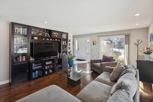 living room featuring dark wood-type flooring and a textured ceiling