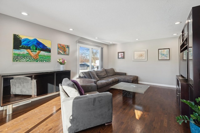 living room with dark hardwood / wood-style floors and a textured ceiling