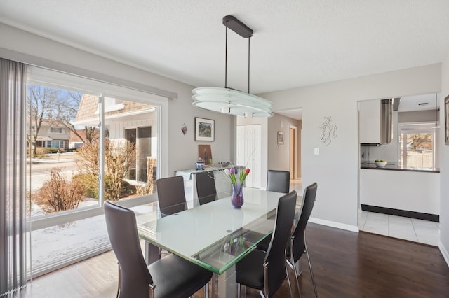 dining space with dark wood-type flooring and a textured ceiling