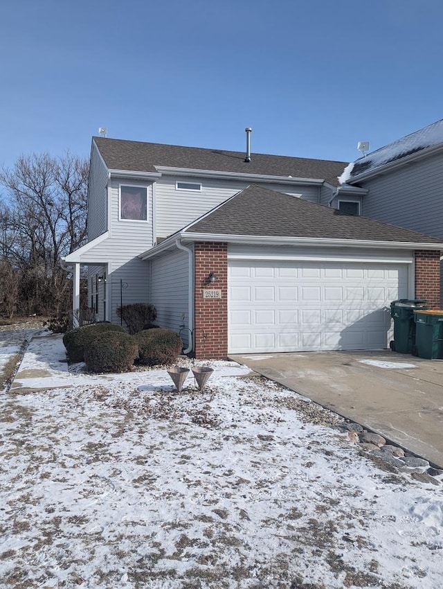 view of snow covered exterior with a garage