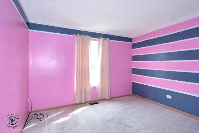 carpeted spare room featuring plenty of natural light, visible vents, baseboards, and ornamental molding