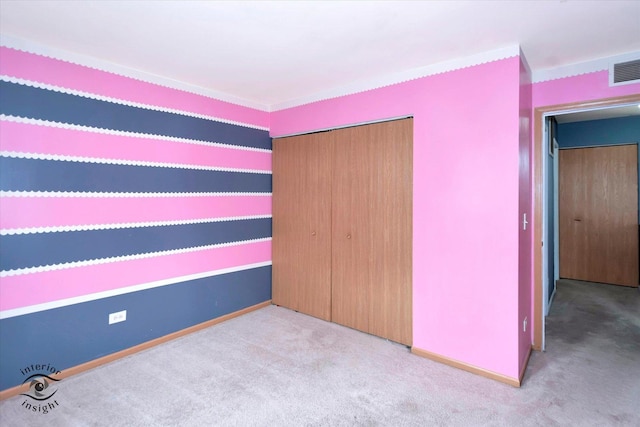 unfurnished bedroom featuring visible vents, baseboards, carpet floors, and a closet