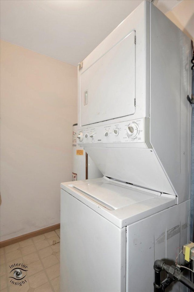 laundry area featuring stacked washer and clothes dryer, baseboards, and laundry area