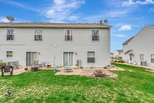 back of house featuring central air condition unit, a yard, a patio, and an outdoor fire pit