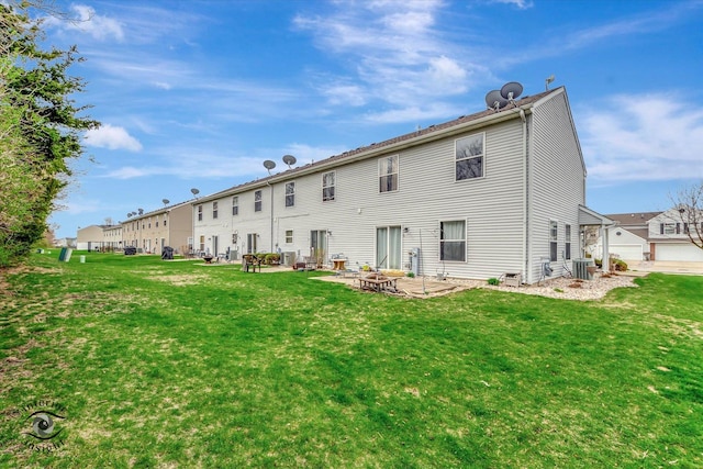 back of property with central air condition unit, a patio, an outdoor fire pit, and a lawn