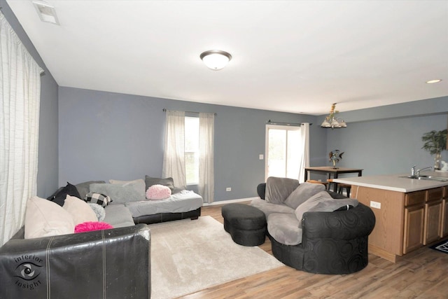 living area with light wood-type flooring and baseboards