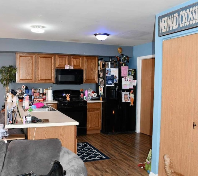 kitchen with sink, a kitchen breakfast bar, dark hardwood / wood-style flooring, kitchen peninsula, and black appliances