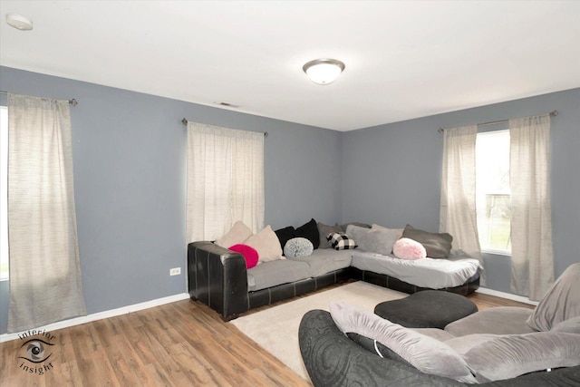 living area with visible vents, baseboards, and wood finished floors