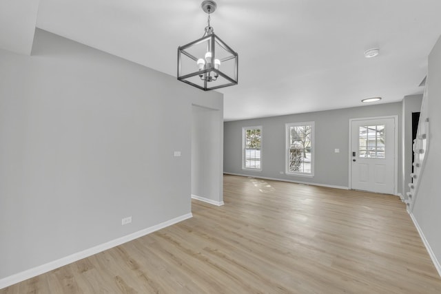 unfurnished living room featuring light hardwood / wood-style floors and a chandelier