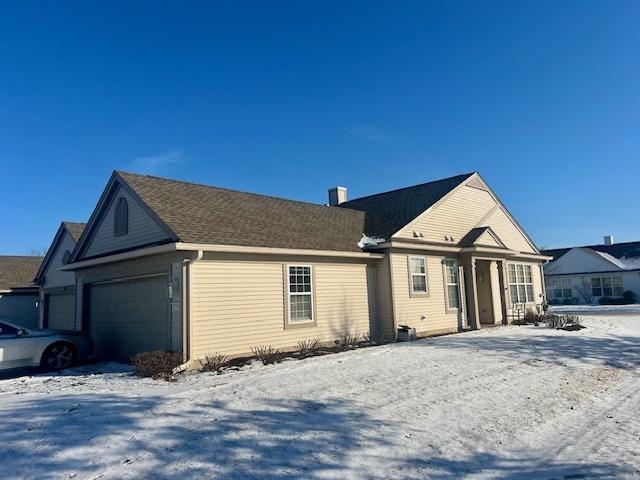 view of snow covered exterior with a garage