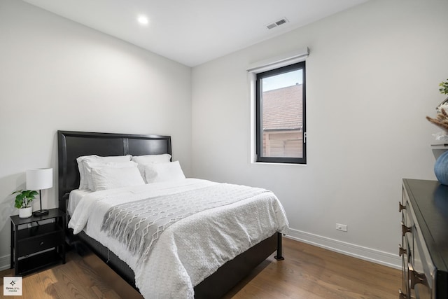 bedroom with dark hardwood / wood-style flooring