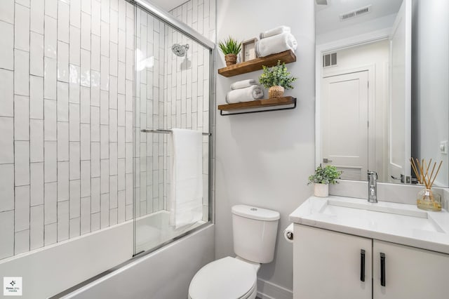 full bathroom featuring vanity, enclosed tub / shower combo, and toilet