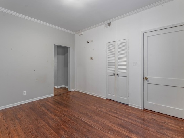 empty room with ornamental molding and dark wood-type flooring