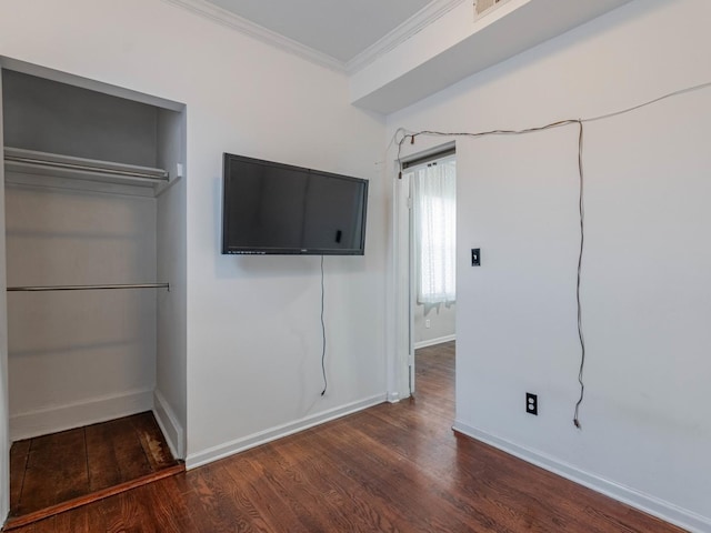 unfurnished bedroom featuring dark wood-type flooring, ornamental molding, and a closet