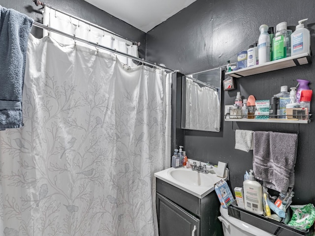 bathroom featuring vanity, toilet, and curtained shower