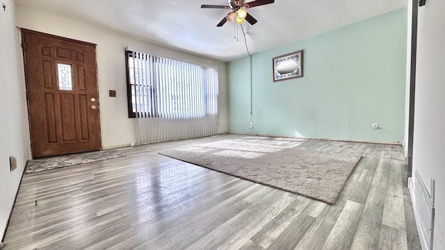 foyer with ceiling fan and light wood finished floors