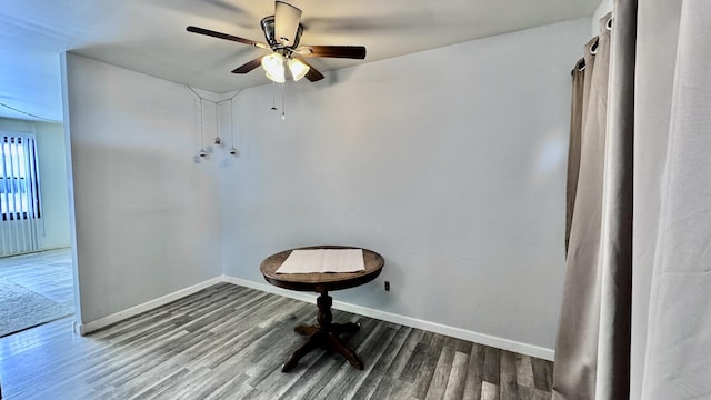 unfurnished room featuring ceiling fan, wood finished floors, and baseboards