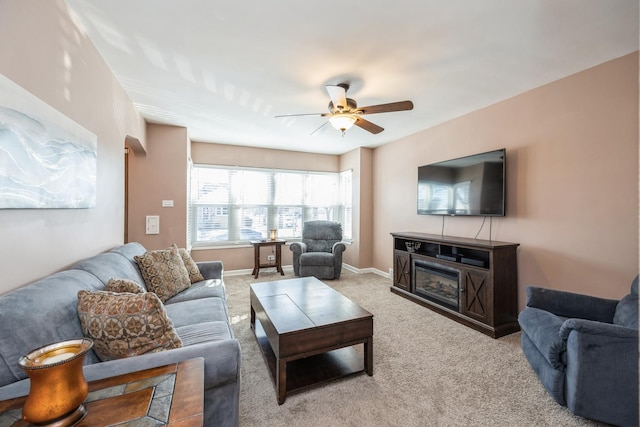 carpeted living room featuring a ceiling fan and baseboards