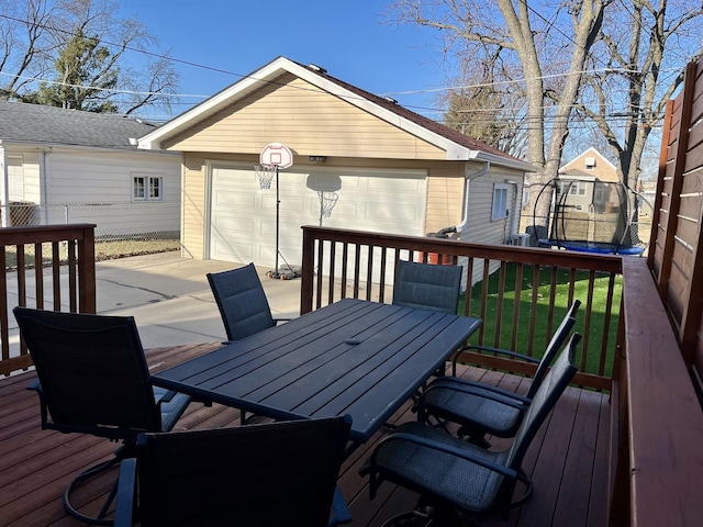 wooden deck with a yard, a trampoline, an outdoor structure, and fence