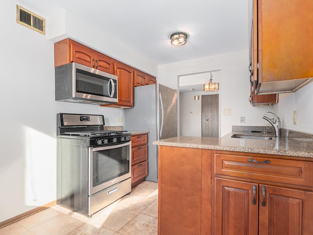 kitchen featuring light stone countertops, appliances with stainless steel finishes, sink, and kitchen peninsula