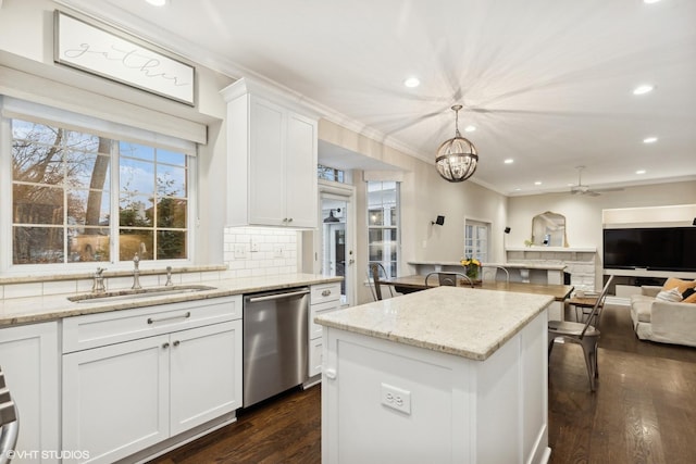 kitchen featuring pendant lighting, sink, dishwasher, white cabinets, and ceiling fan with notable chandelier