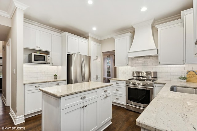 kitchen featuring sink, white cabinetry, stainless steel appliances, light stone countertops, and custom range hood