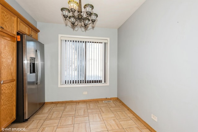 kitchen featuring a chandelier and stainless steel fridge with ice dispenser