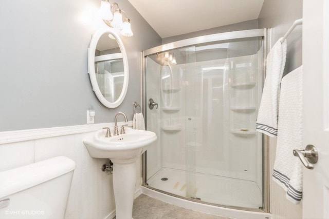 bathroom with tile patterned floors, a shower with door, and toilet