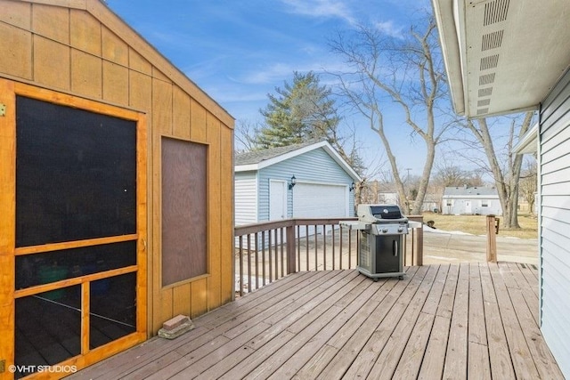 deck with a grill, a garage, and an outdoor structure