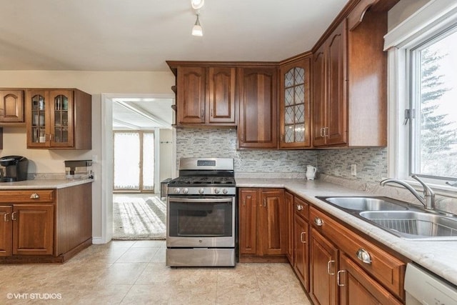 kitchen featuring dishwasher, sink, stainless steel range with gas stovetop, and a wealth of natural light