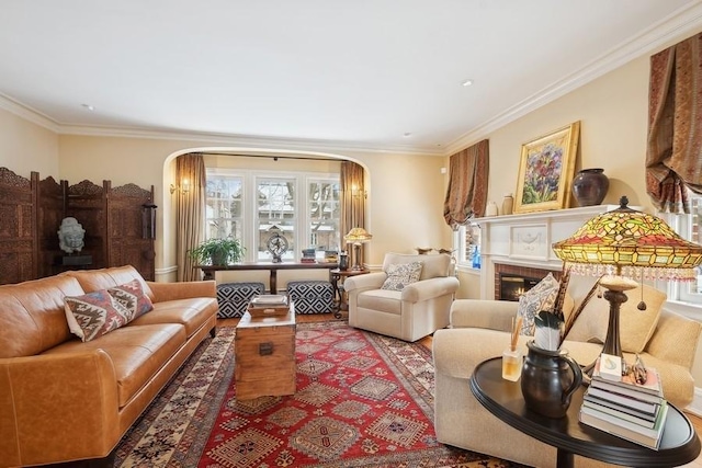 living room with a brick fireplace, plenty of natural light, and crown molding