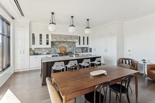 dining space featuring crown molding, plenty of natural light, and wood finished floors