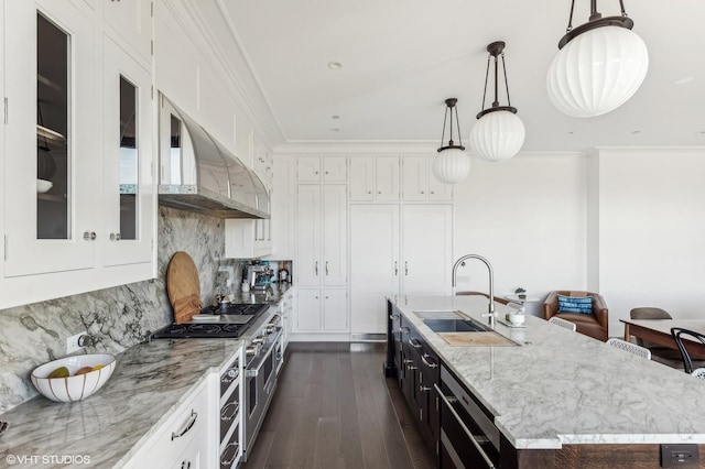 kitchen featuring range with two ovens, ornamental molding, a sink, extractor fan, and white cabinetry