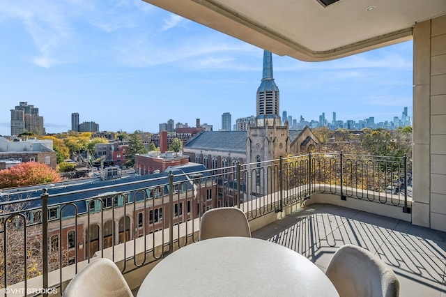 balcony featuring a city view and outdoor dining space