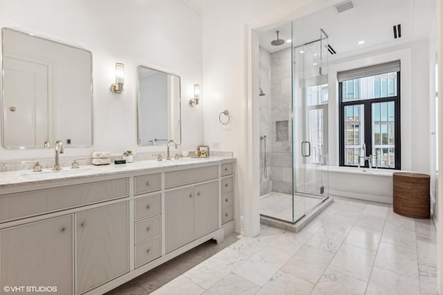 bathroom featuring a sink, visible vents, a stall shower, and double vanity