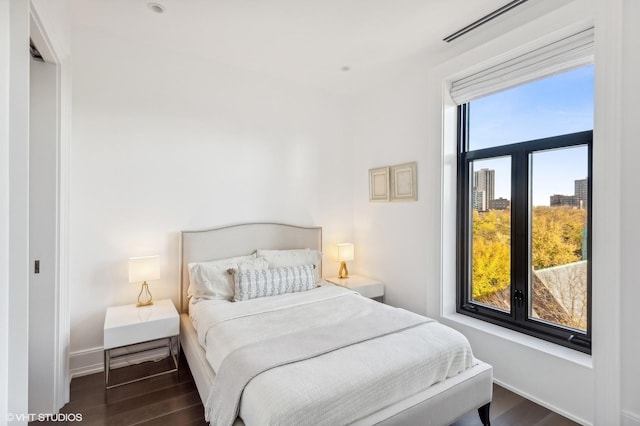 bedroom featuring visible vents, baseboards, and wood finished floors