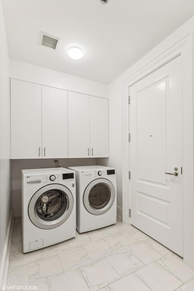 laundry room with cabinet space, visible vents, marble finish floor, and washing machine and clothes dryer